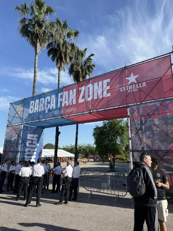 Arco de entrada a la Barça Fan Zone con aficionados accediendo al recinto.